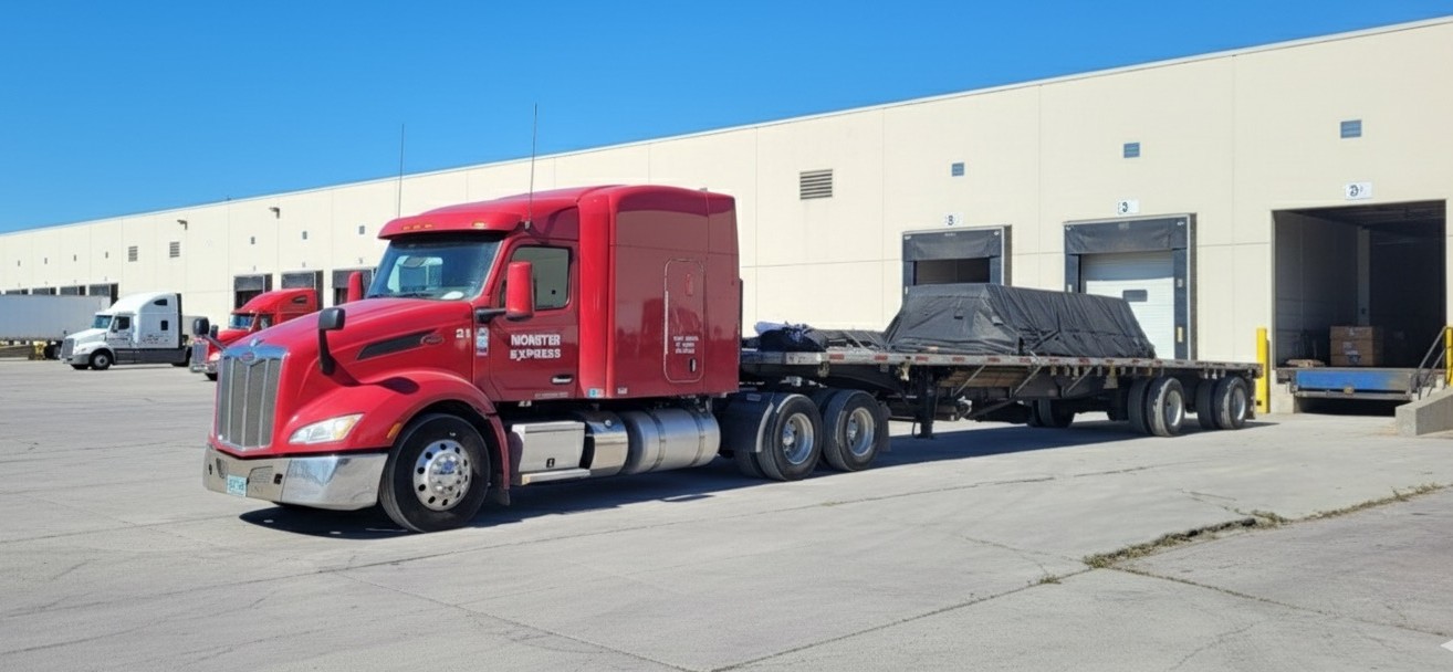 Monster Express Inc flatbed truck with trailer at loading facility ready for transportation service